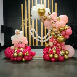 Pink, white, and gold balloon arch with floral balloon decorations styled by a party decorator for a chic baby shower party backdrop.