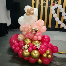 Pink, white, and gold balloon arch with floral balloon decorations styled by a party decorator for a chic baby shower party backdrop.